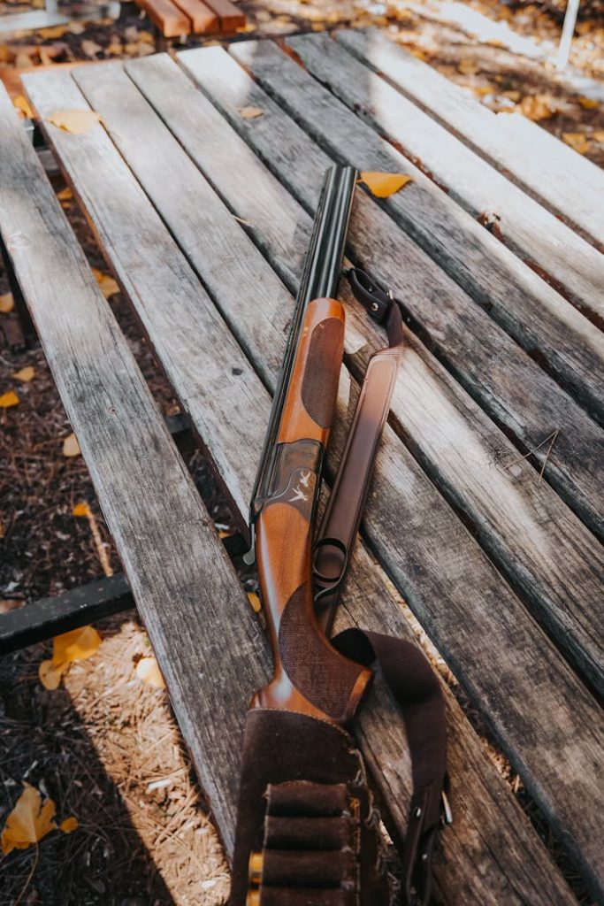 Crafting Captivating Headlines: Your awesome post title goes here A hunting shotgun rests on a wooden bench surrounded by autumn leaves.
